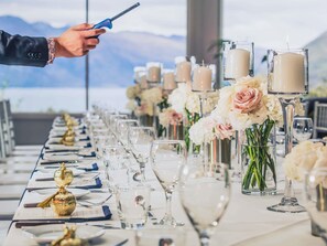 A table set for a formal event with clear glassware, candles, and floral centerpieces.