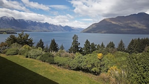 A lake with mountains in the background and dense greenery in the foreground. - Mercure Queenstown Resort (Queenstown)