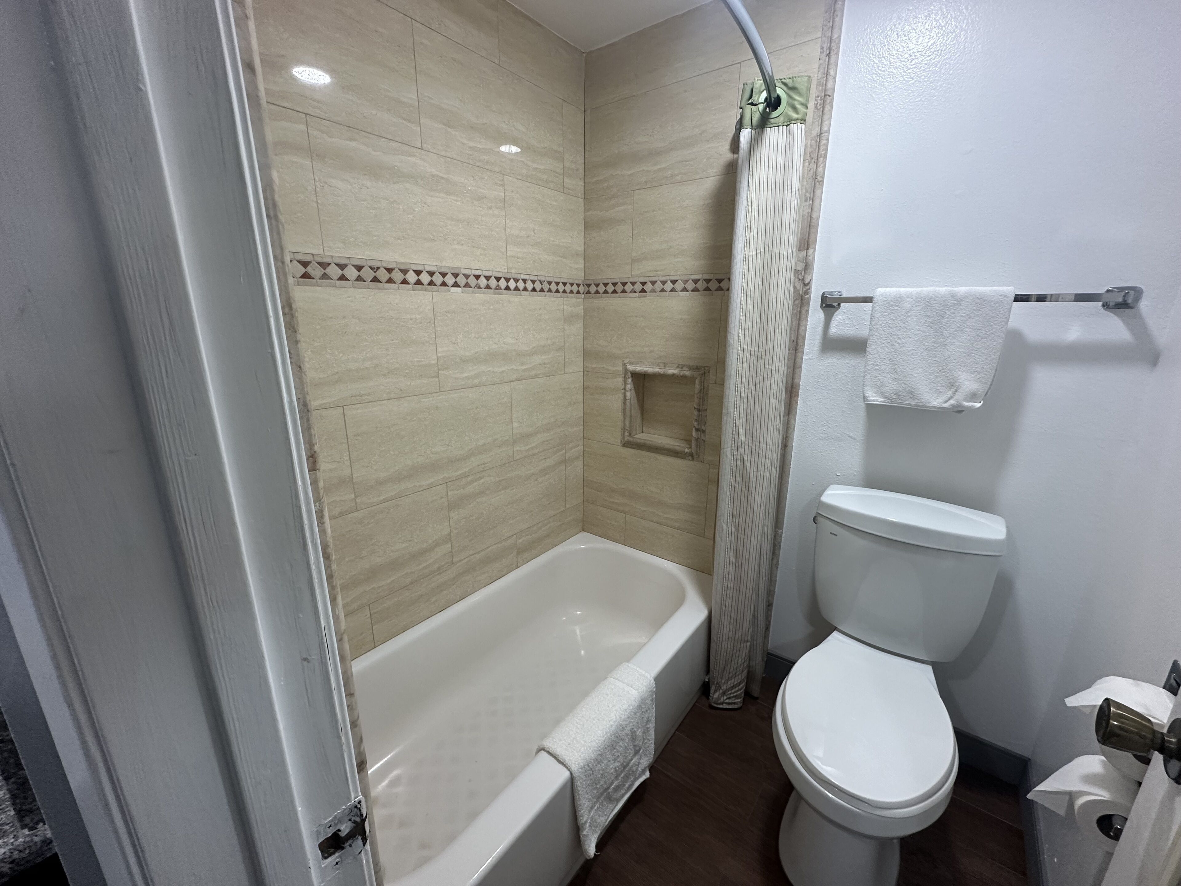 A bathroom with a bathtub, toilet, and shower curtain.