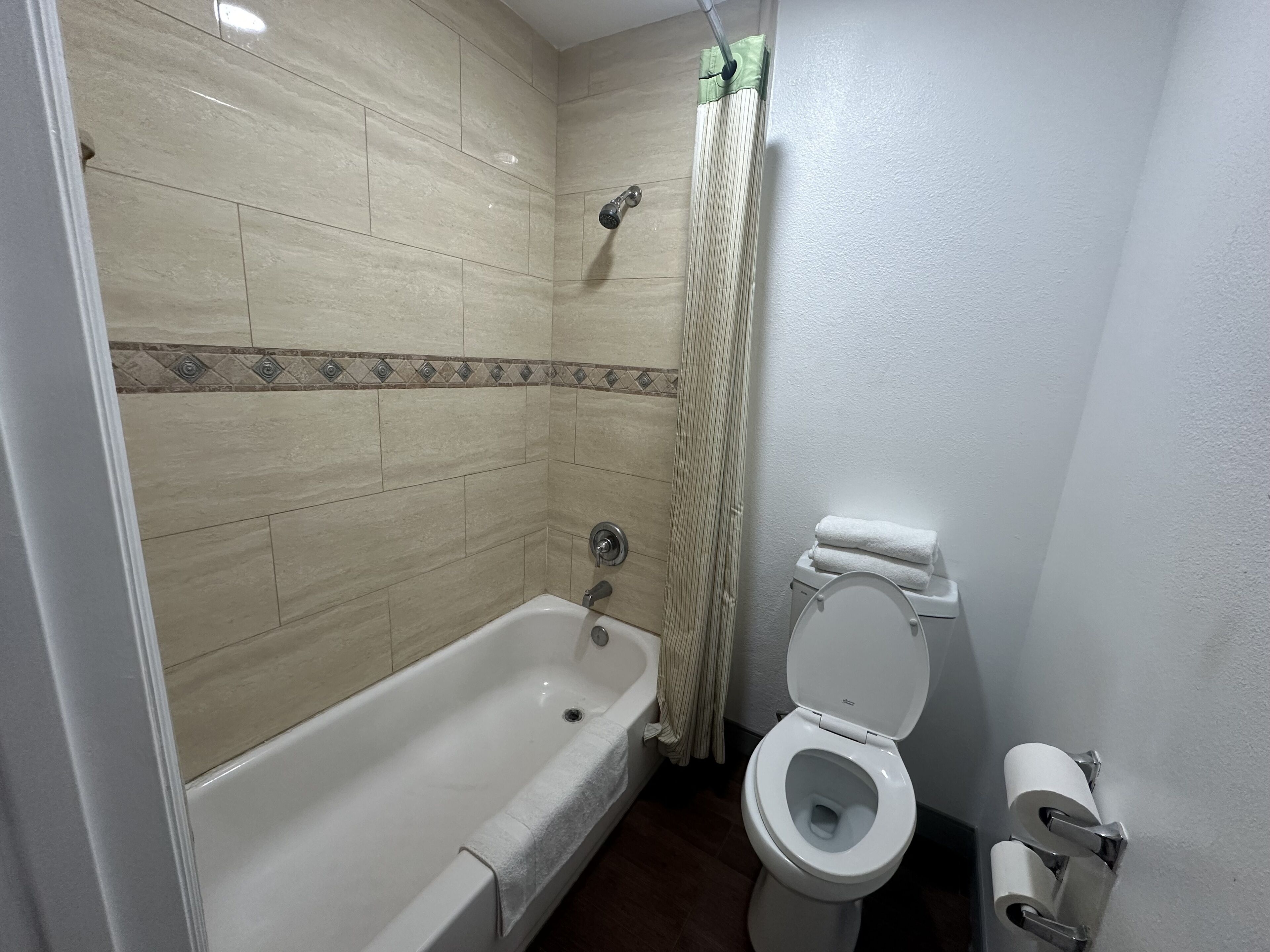 Ein Badezimmer mit Badewanne, Toilette und Duschvorhang.