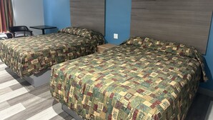 Habitación de hotel con dos camas, un escritorio y una silla.