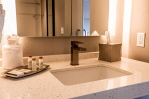 A bathroom with a sink, mirror, towel rack, and toiletries. - Hotel Indigo Harrisburg - Hershey by IHG (Harrisburg)