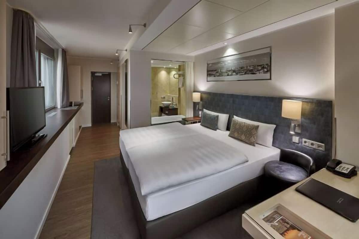 Ropa de cama hipoalergénica y caja de seguridad en la habitación