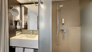 A modern bathroom with a sink, mirror, and shower.