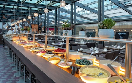 A buffet setup in a modern restaurant with various food items and a long counter.
