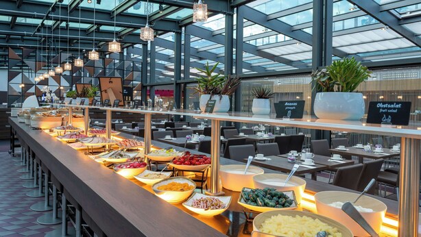 A buffet setup in a modern restaurant with various food items and a long counter.