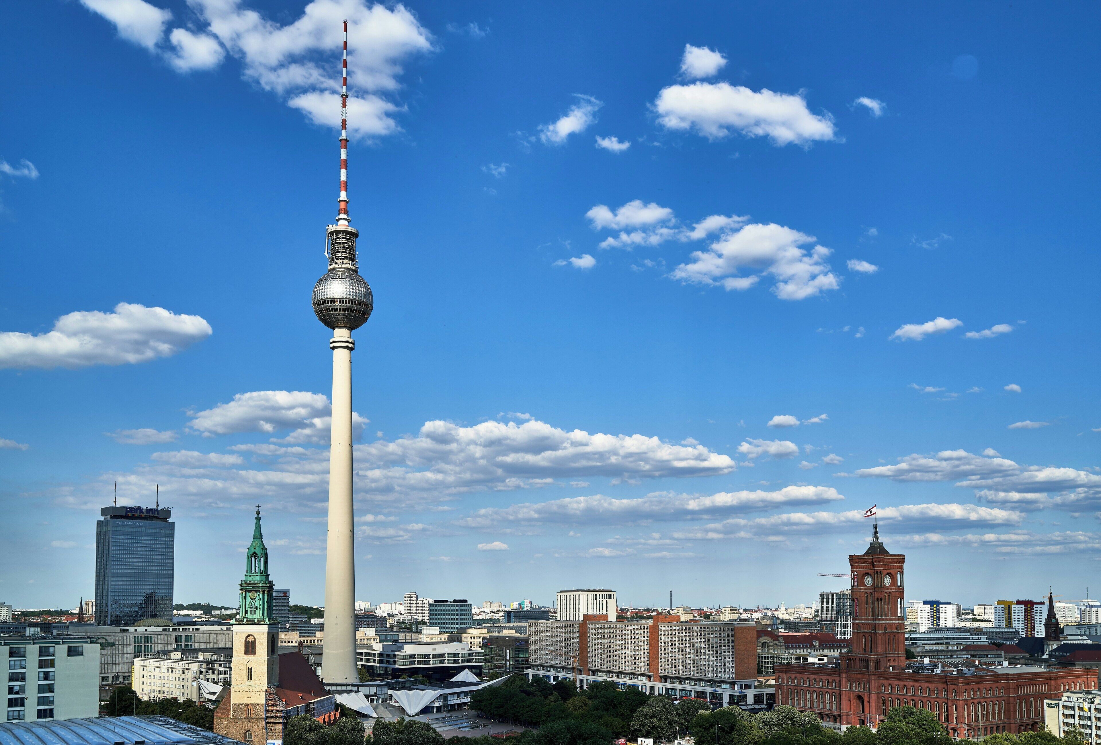 A cityscape with a prominent tower, a clock tower, and modern buildings.