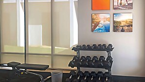 A gym with a bench, dumbbells, and a treadmill. - Comfort Inn & Suites Buffalo Airport (Buffalo)