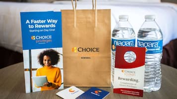A promotional display for Choice Privileges Rewards, including a brochure, a brown paper bag, two water bottles, and two loyalty cards.