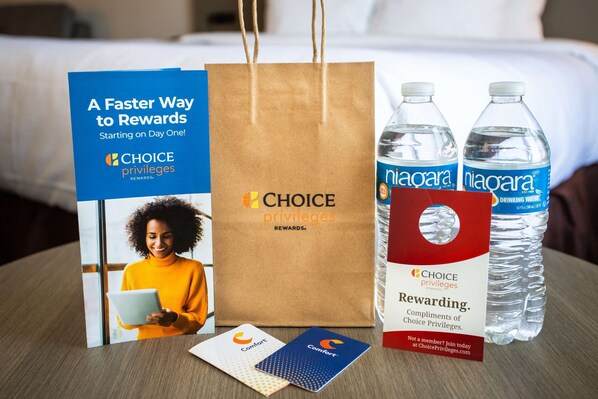 Un présentoir promotionnel pour le programme de fidélité Choice Privileges Rewards, comprenant une brochure, un sac en papier kraft, deux bouteilles d’eau et deux cartes de fidélité.