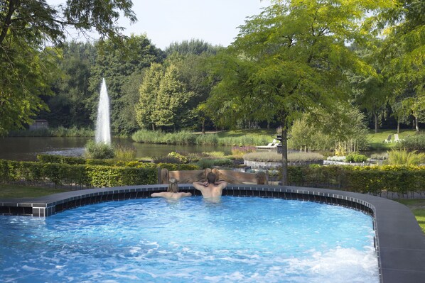 Relax by the serene pool surrounded by lush gardens and a small waterfall.