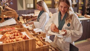 A buffet setup with various baked goods, including croissants and bread, in wooden containers. - Thermen Bad Nieuweschans (Bad Nieuweschans)