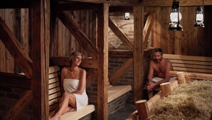 A rustic wooden sauna with benches and a hay-filled area. - Thermen Bad Nieuweschans (Bad Nieuweschans)