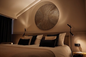 Relax in a serene space with a large bed, wall-mounted artwork, and bedside lamps.