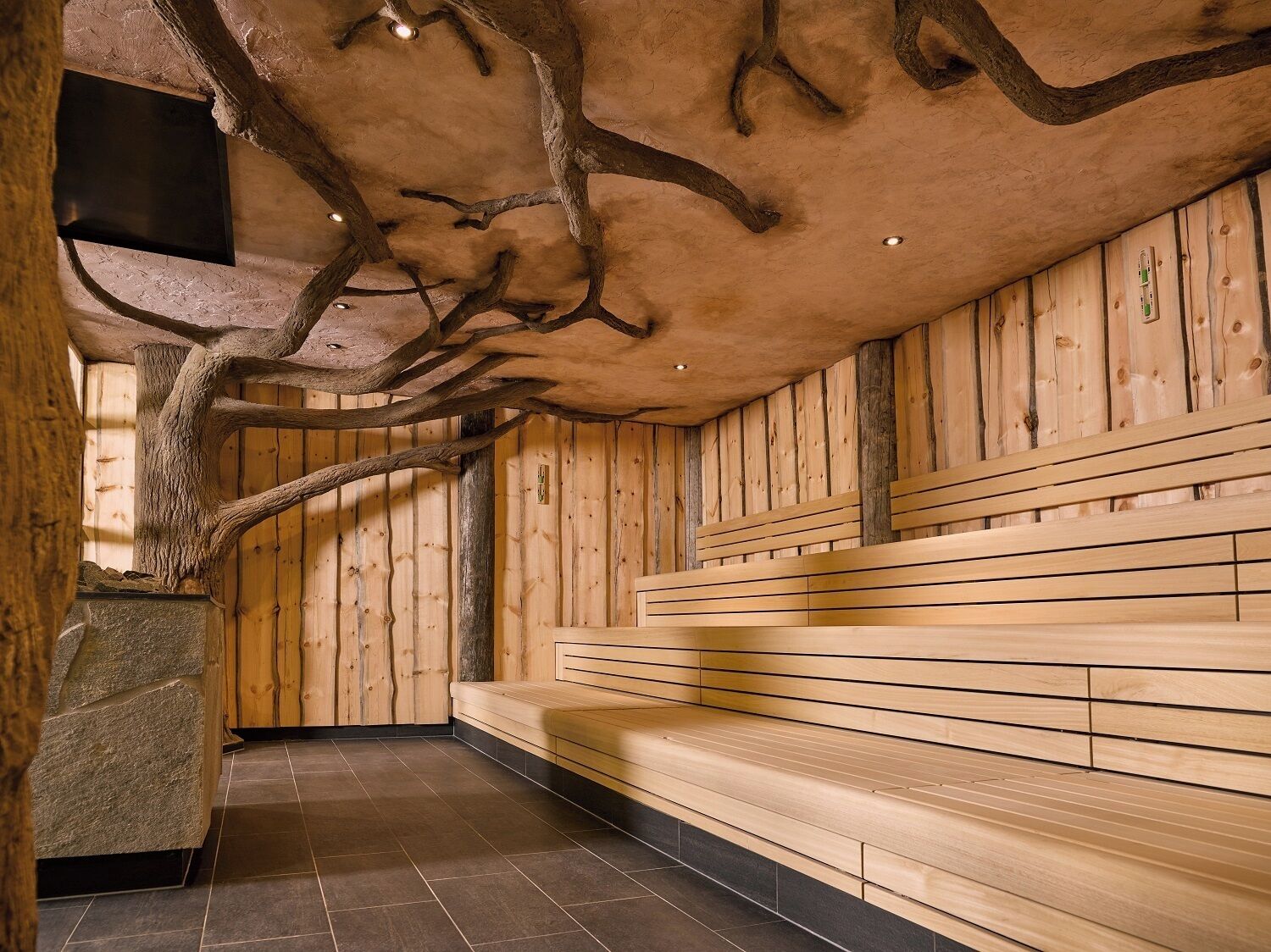A wooden interior with a bench and a stone structure.