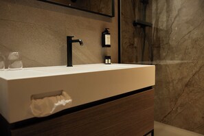 Features a sleek vanity with a black faucet and white countertop, along with a convenient drawer and storage space.