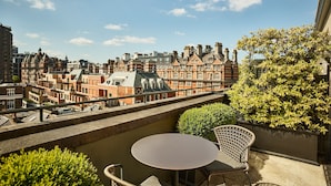 A balcony with a table and chairs, overlooking a cityscape with historic buildings. - The Berkeley, Maybourne  (London)