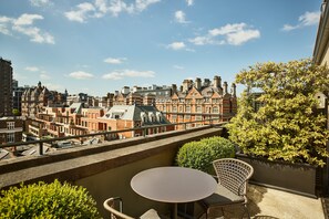 A balcony with a table and chairs, overlooking a cityscape with historic buildings. - The Berkeley, Maybourne  (London)