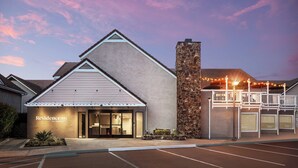 Un hotel de diseño moderno, con fachada de piedra y balcón con luces de cuerda.