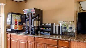 A coffee station with a coffee machine, a fruit juice dispenser, and a beverage dispenser. - Americas Best Value Inn & Suites Ft. Collins E at I-25 (Fort Collins)
