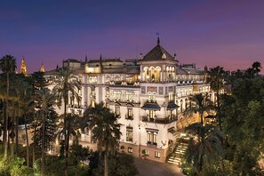 A large, ornate building with multiple balconies and a central dome, surrounded by palm trees. - Hotel Alfonso XIII, a Luxury Collection Hotel, Seville (Seville)