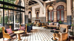A spacious lounge with a checkered floor, comfortable seating, and large windows offering views of the outside.