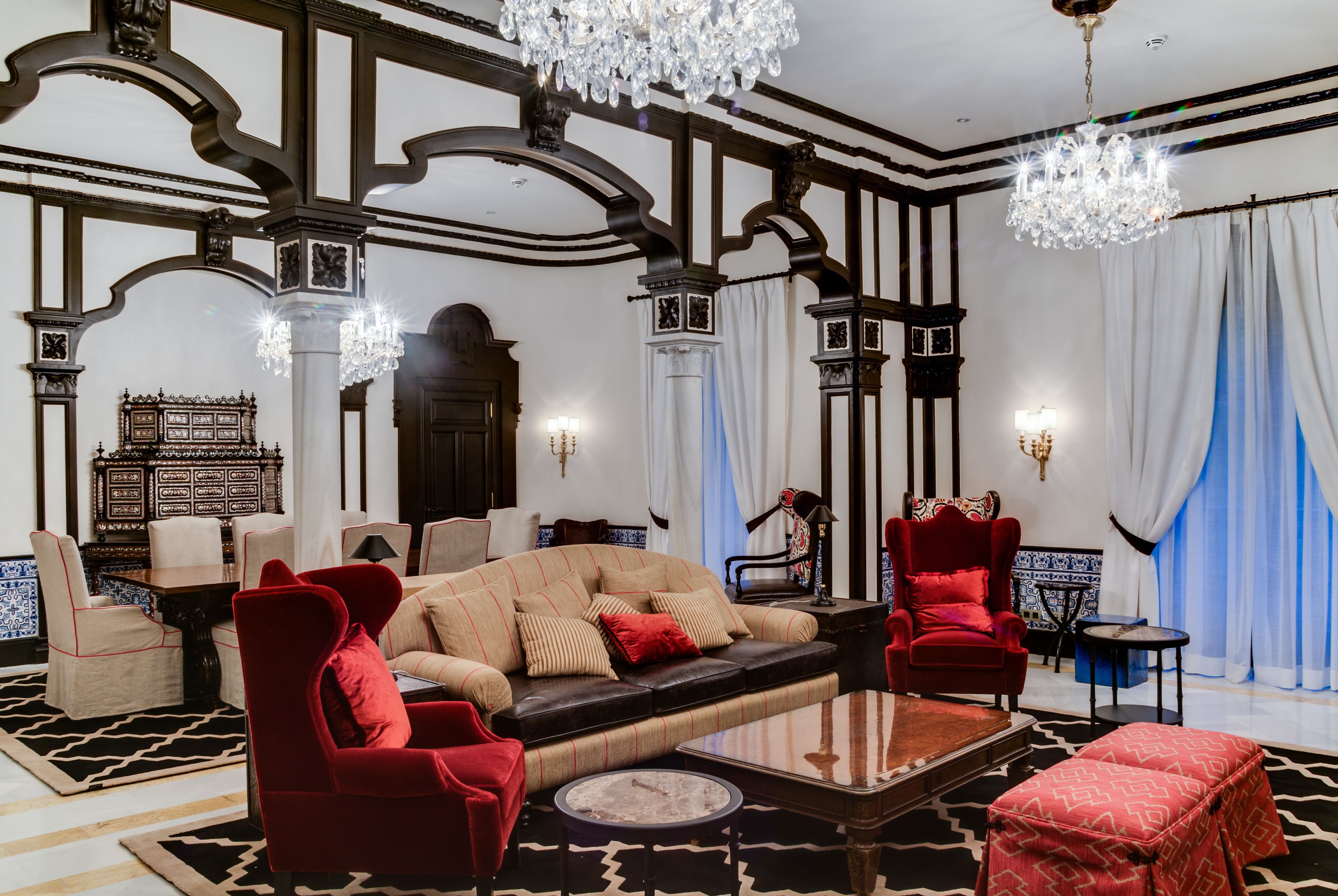 A luxurious living room with a sofa, armchairs, a coffee table, and a chandelier.