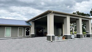 A building with a covered entrance, columns, and a sign that reads "CLOUSE ARRANCE." - Days Inn by Wyndham DeFuniak Springs (De Funiak Springs)