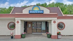 A Days Inn with a prominent sign, a tiled entrance, and potted plants at the entrance. - Days Inn by Wyndham Washington Pennsylvania (Washington)
