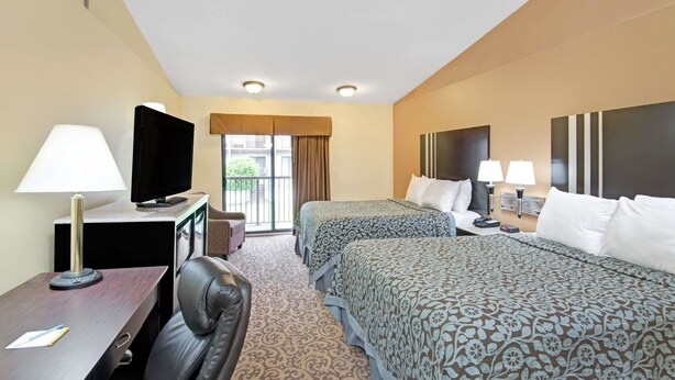 A hotel room with two beds, a desk with a lamp, a television, and a chair. - Days Inn by Wyndham Washington Pennsylvania (Washington)