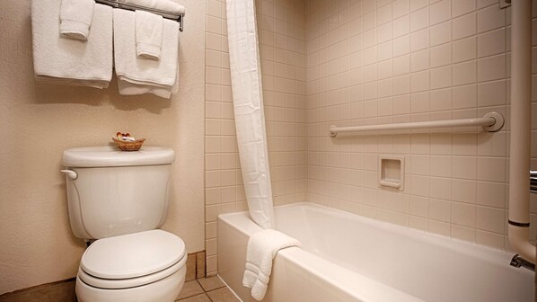 A bathroom with a toilet, a bathtub, and a shower curtain. - Best Western Sandman Hotel (Sacramento)