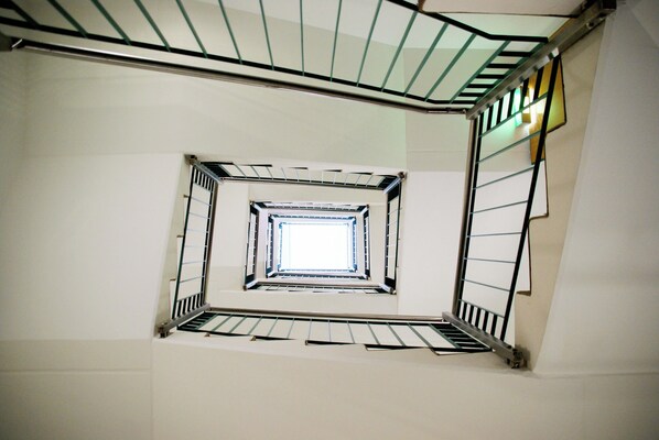 Una escalera de caracol con barandas de metal y una vista del cielo en la parte superior.