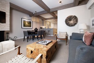 Una sala de estar moderna con chimenea, un comedor y una cocina al fondo.