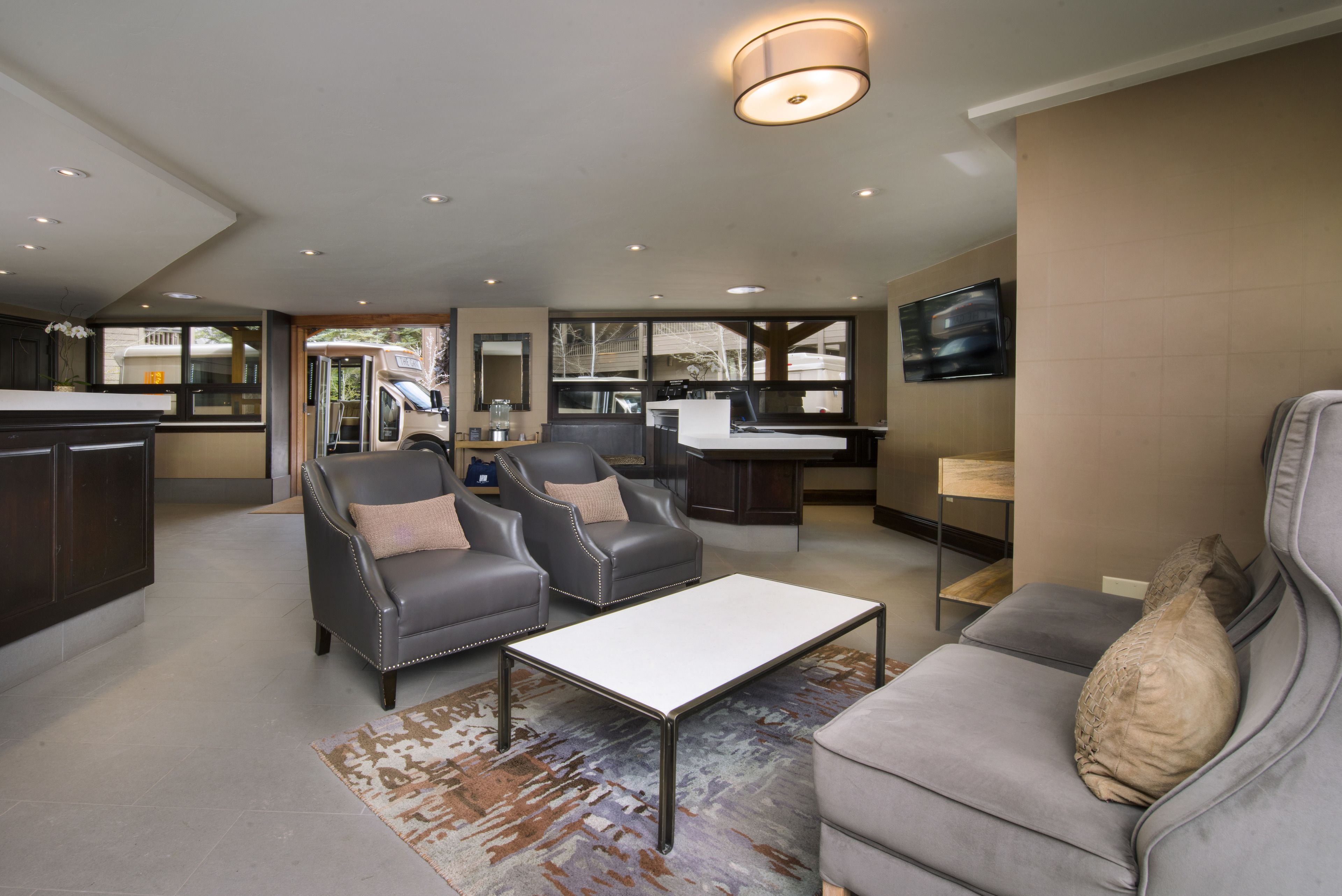 Un espacio moderno para relajarse con un sofá, dos sillones, una mesa de centro y un televisor.
