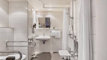 Ein modernes Badezimmer mit Toilette, Waschbecken, Dusche und Spiegel.
