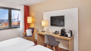 A hotel room with a bed, a desk, a chair, a TV, and a window with curtains. - Best Western Hotel Bochum (Bochum)