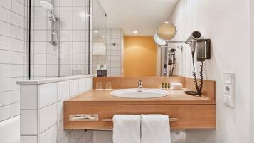Ein modernes Badezimmer mit Dusche, Waschbecken und Spiegel.