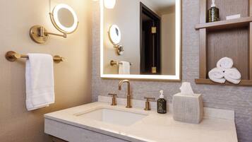 Une salle de bain moderne avec un grand miroir, un lavabo et un porte-serviettes.