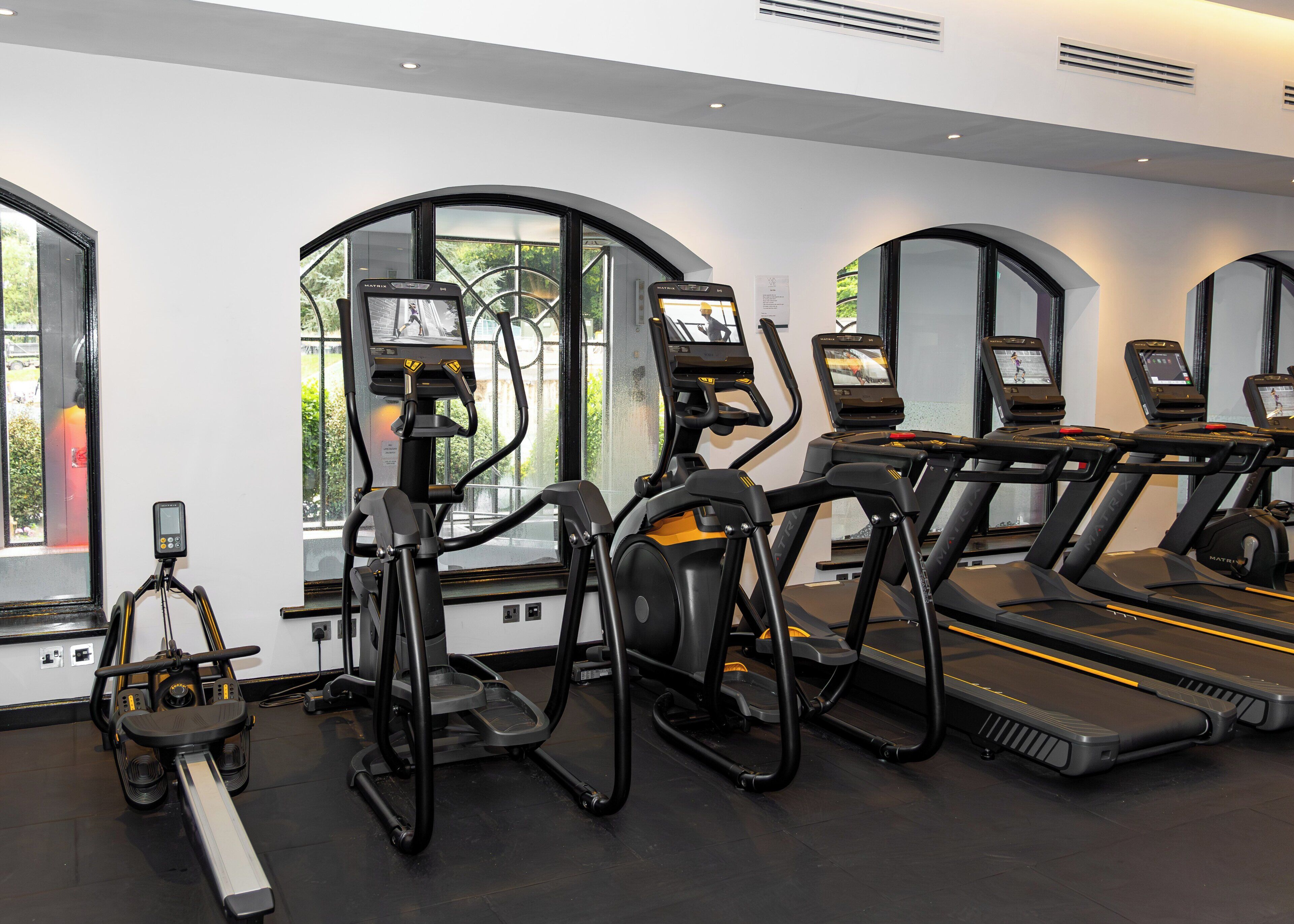 A gym with treadmills, ellipticals, and a stationary bike.