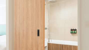 A modern bathroom with a wooden sliding door, a shower, and a toilet.