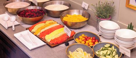 A buffet with various food items and utensils.
