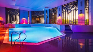 A modern indoor swimming pool with a geometric design, large windows, and ambient lighting. - Crowne Plaza Gerrards Cross by IHG (Beaconsfield)