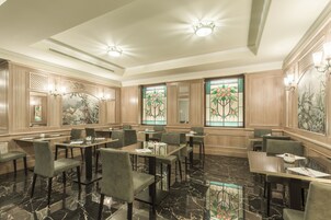 Un'ampia sala da pranzo con pavimento in marmo, diversi tavoli e sedie.