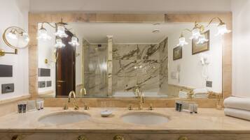 Un baño con dos lavamanos, un espejo grande y una ducha.