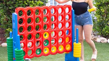 A person playing a game with a colorful board game set up on artificial grass.