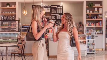 Deux femmes sont assises dans un café, chacune tenant une boisson.
