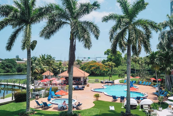 Una piscina al aire libre, sillones reclinables de piscina