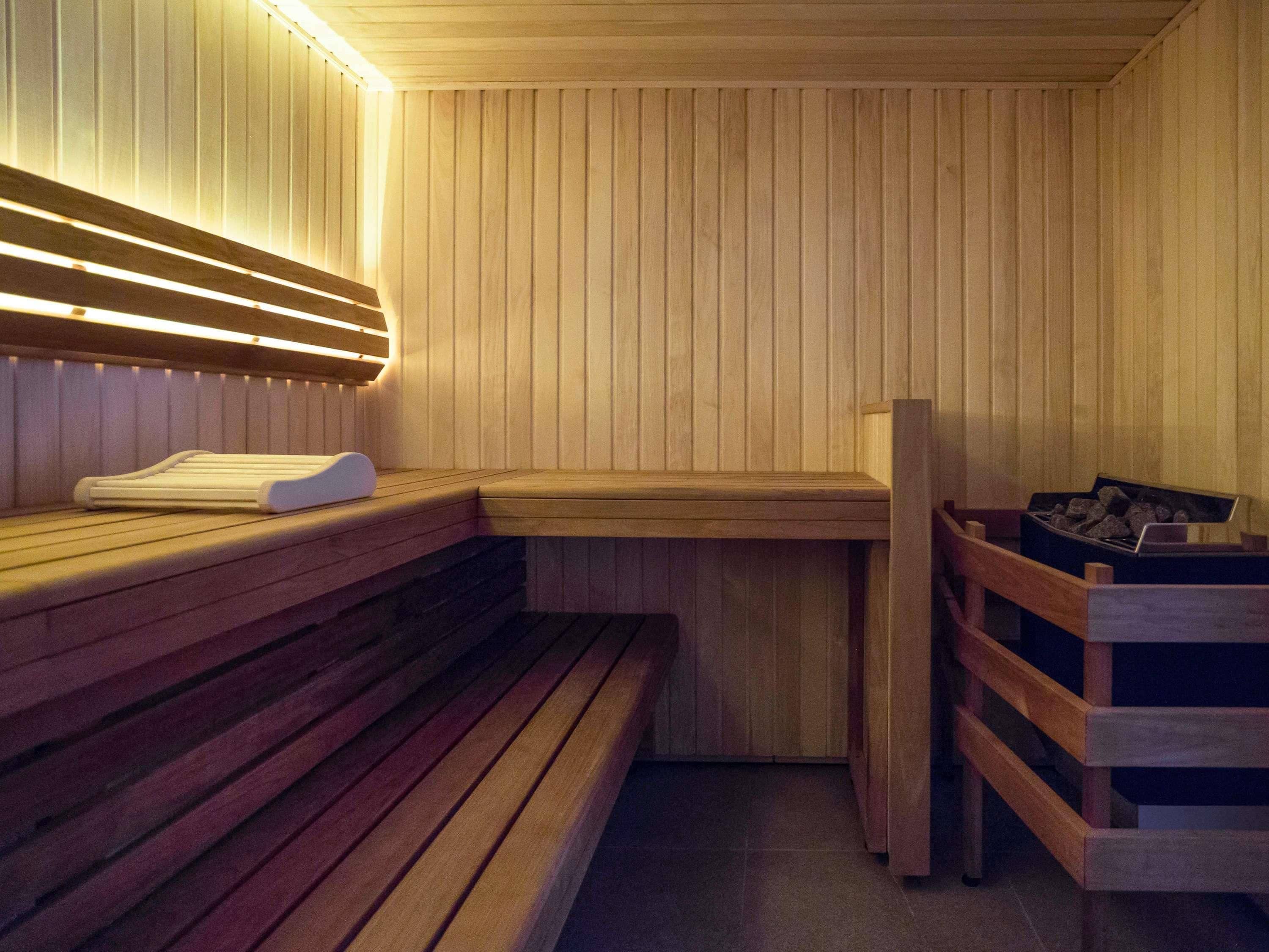 A sauna with wooden benches and a bench with a towel.