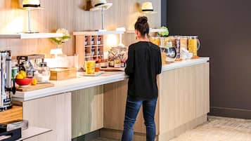Una persona de pie frente a un mostrador con diferentes alimentos y condimentos.