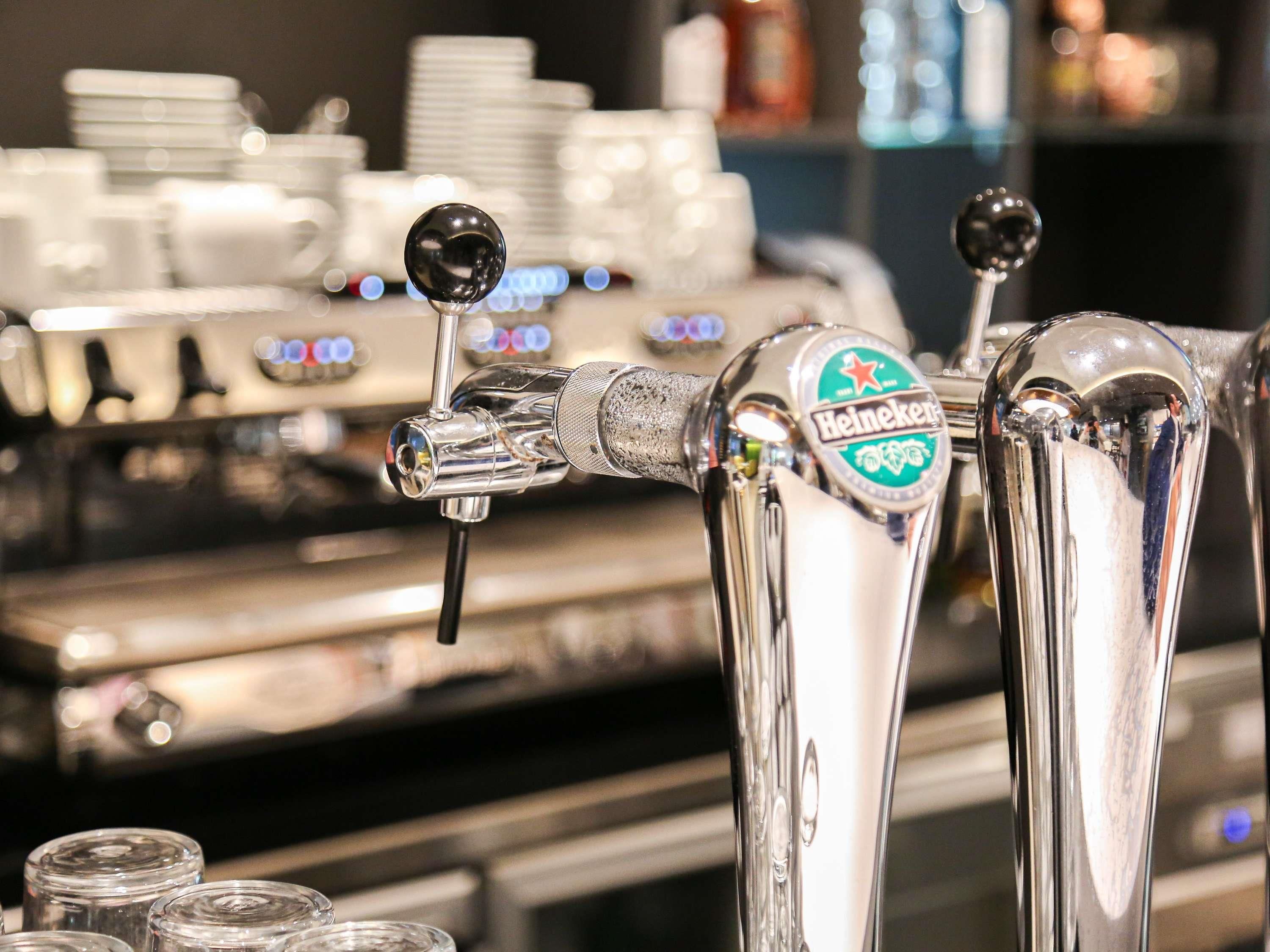 A bar tap with a Heineken logo, a spout, and a handle.